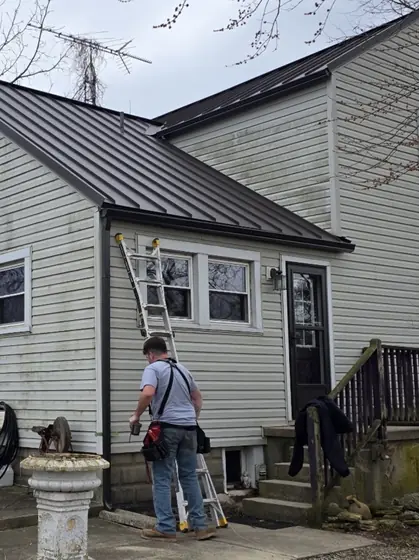 KSG installer on a ladder fitting gutter to a house